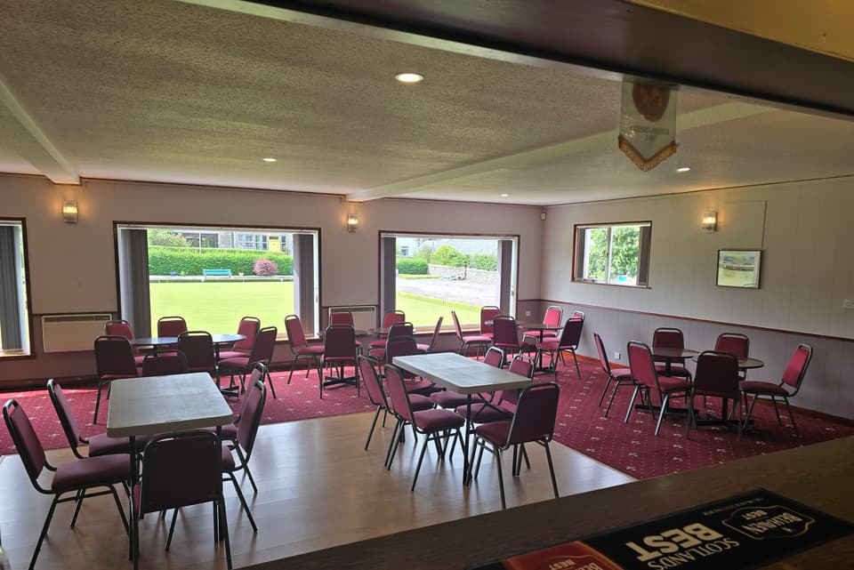 Function room with tables and chairs beside the bar