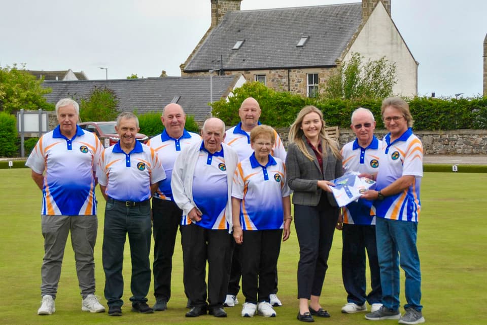 Cullen bowlers receiving new club shirts on the green